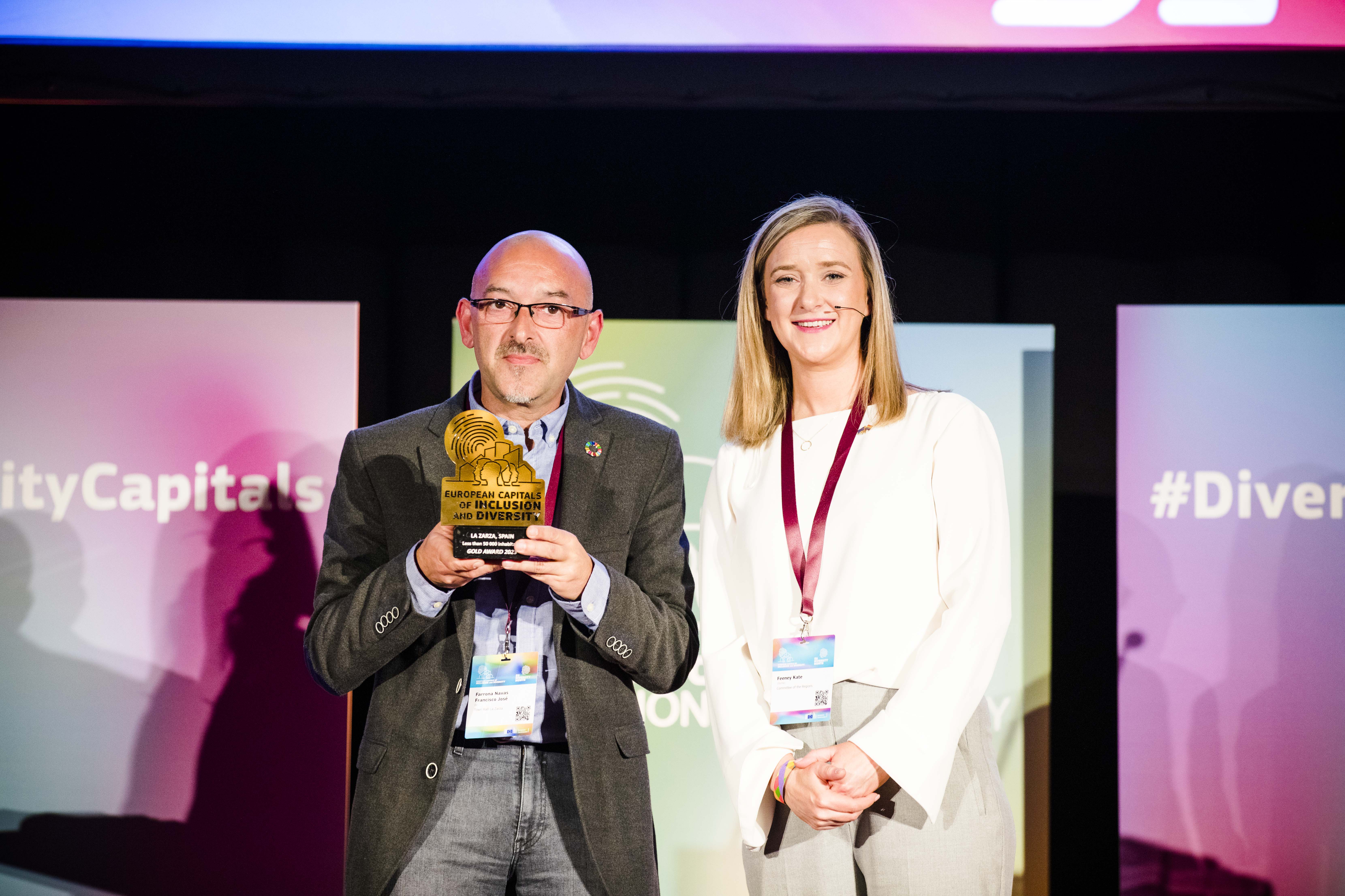The Mayor of La Zarza, Mayor Francisco Jose Farrona Navas, standing next to Kate Feeny, Member of the Committee of the Regions, holding the Gold Award for the 2023 European Capitals of Inclusion and Diversity. © European Union, 2023